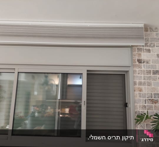 תריסים וחלון זכוכית על קיר לבנים